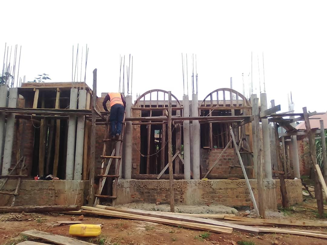 Residential building under construction with scaffolding and workers.
