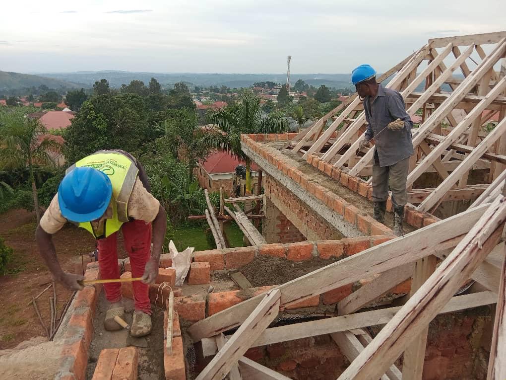 CHI-IBANDA workers carrying out roofing and structural brickwork on a residential building site.