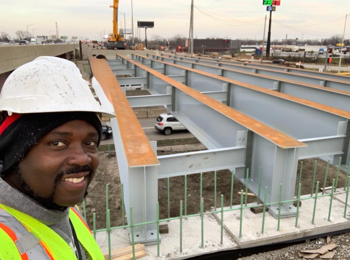 Infrastructure construction with bridge steel girders and active road works.